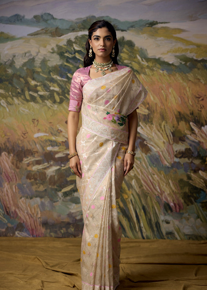 Luxury off white handwoven Kota tissue saree with silver zari floral jaal, pastel floral accents, antique gold and silver zari Jharokha pallu, elegant heritage border and premium festive designer craftsmanship by Sonchiraiya
