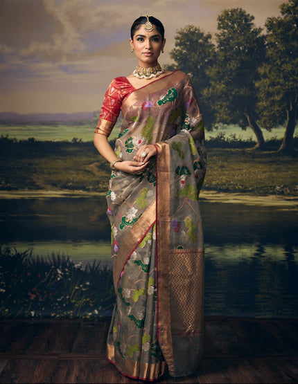 Luxury grey handwoven Kota saree with silver zari lotus jaal, gold zari detailing, crimson floral accents, gold zari chevron pallu, minimal zari border and premium festive heritage designer craftsmanship by Sonchiraiya
