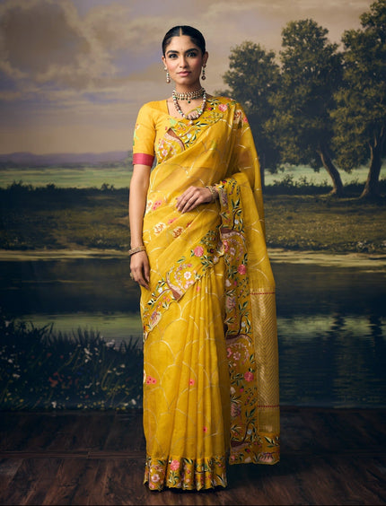 Luxury mustard yellow handwoven Kota saree with silver zari scallop weave, pastel floral motifs, gold zari chevron pallu, jungle story border and premium festive designer craftsmanship by Sonchiraiya