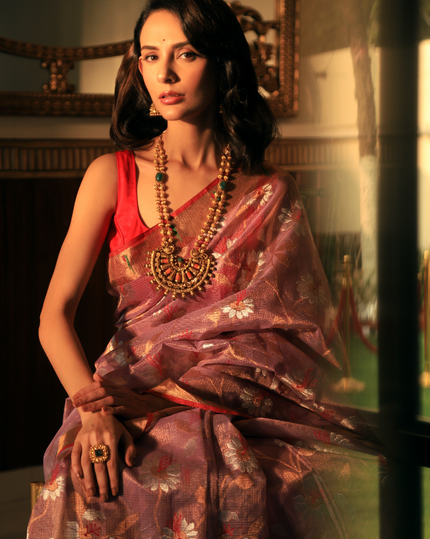 Woman wearing a lavender SónChiraiya zari Kota handloom saree, with Muniya border and floral motifs in gold and silver zari.