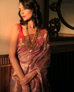 Woman wearing a lavender SónChiraiya zari Kota handloom saree, with Muniya border and floral motifs in gold and silver zari.
