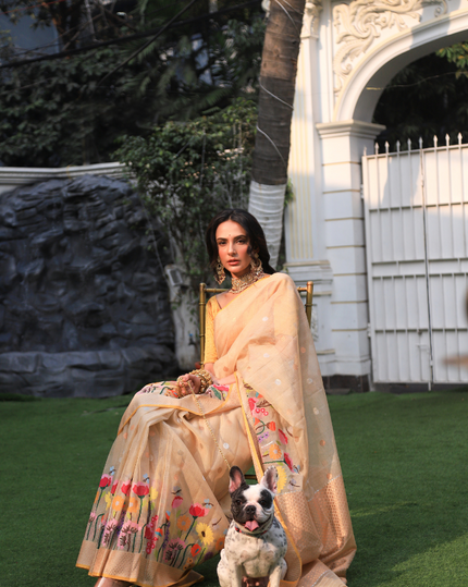 Woman wearing a beige SónChiraiya zari Kota handloom saree, with blooming vibrant flowers, gold and silver zari polka dots and a gold zari border.  