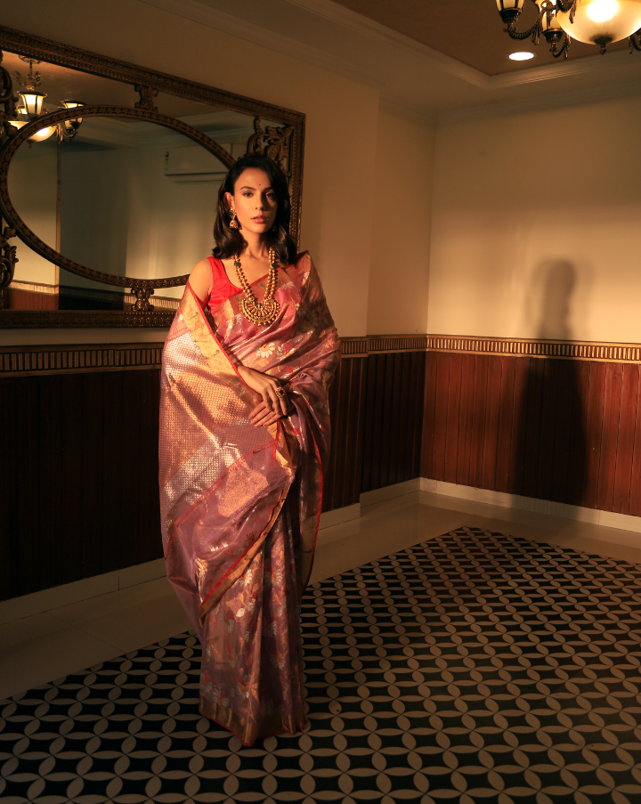 Woman wearing a lavender SónChiraiya zari Kota handloom saree, with Muniya border and floral motifs in gold and silver zari.