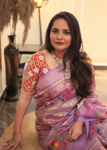 Luxury soft lavender handwoven Kota tissue saree with gold zari check weave, multicolour floral motifs, richly woven gold zari border, contrast pink edge and premium festive heritage designer craftsmanship by Sonchiraiya