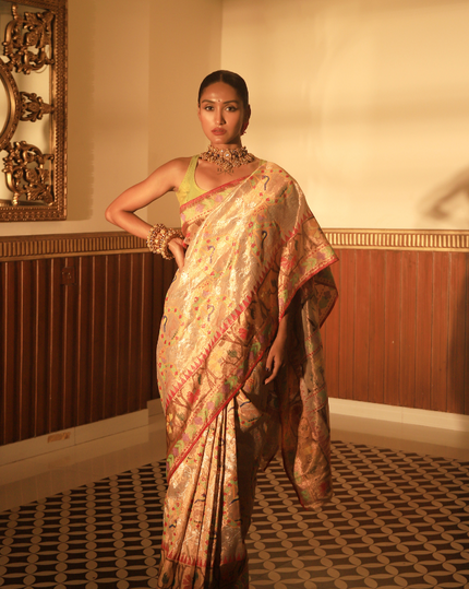 Woman wearing a beige SónChiraiya zari Kota handloom saree with floral, bird and geometric motifs in bright colours.  