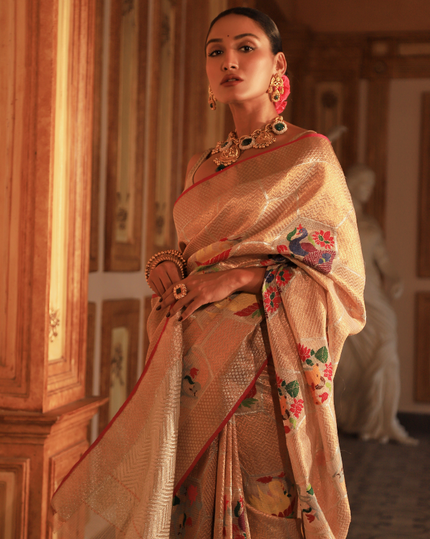 Woman wearing a beige SónChiraiya Kota silk handloom saree with geometric motifs in gold zari and large honeycomb patterns in silver zari. 