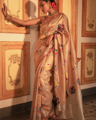 Woman wearing a beige SónChiraiya Kota silk handloom saree with geometric motifs in gold zari and large honeycomb patterns in silver zari. 