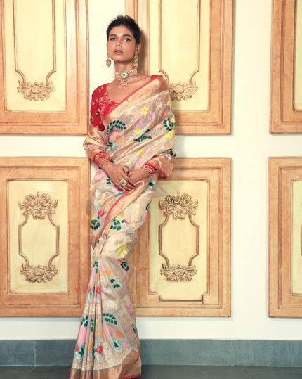 Woman wearing an off-white SónChiraiya zari Kota handloom saree with many-hued florals and gold and silver zari geometric motifs.  