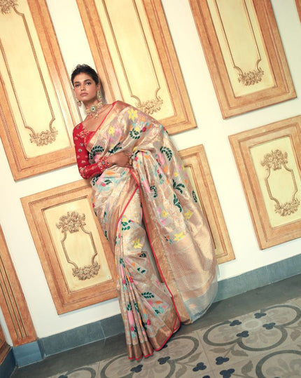 Woman wearing an off-white SónChiraiya zari Kota handloom saree with many-hued florals and gold and silver zari geometric motifs.  